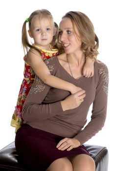 Young mother and little daughter gently embrace. The concept of Happy Childhood, Family Happiness, Raising a Child. Isolated on white background.