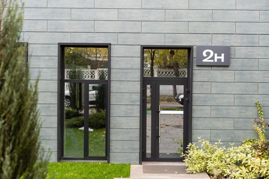 The front door of a office block, reflecting buildings in the glass.