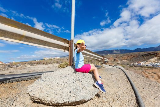 little girl on the side of the road.