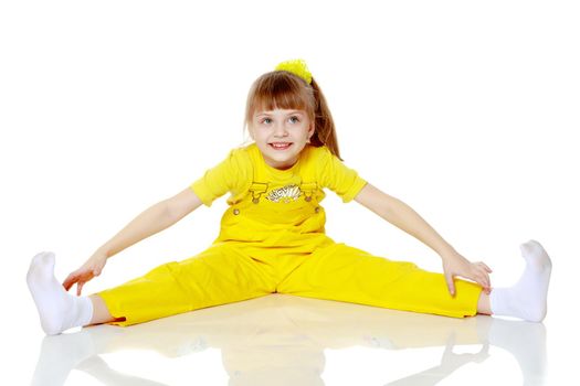 Girl with a short bangs on her head and bright yellow overalls.She crouched down on the white advertising banner.