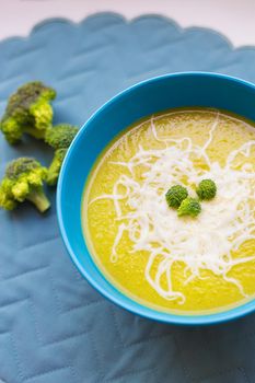 Cream of broccoli soup in the blue plate, close-up