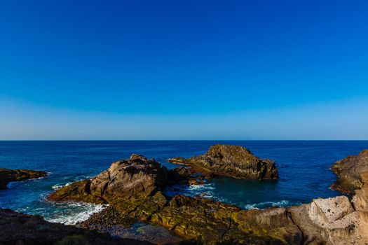 Evening scene on sea, stones, calm ocean.
