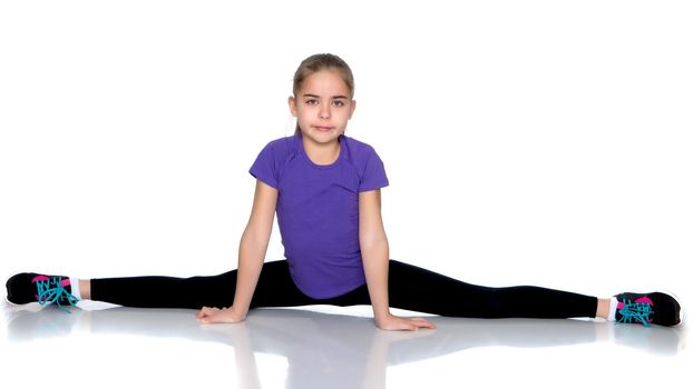 A little girl performs a gymnastic twine. The concept of fitness and sports. Isolated on white background.