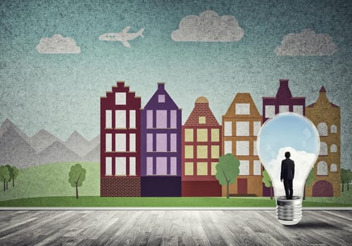 Businessman inside light bulb against city drawn concept