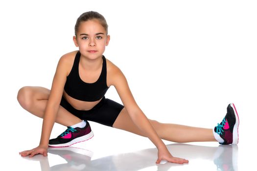 A girl gymnast performs an acrobatic element on the floor. The concept of childhood, sport, healthy lifestyle. Isolated on white background.