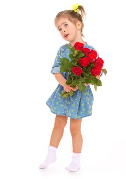 A little girl with a bouquet of red roses in his hands standing on a white background