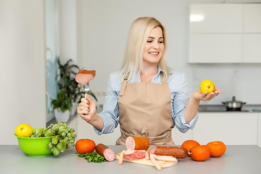 woman holds and chooses between meat and apple