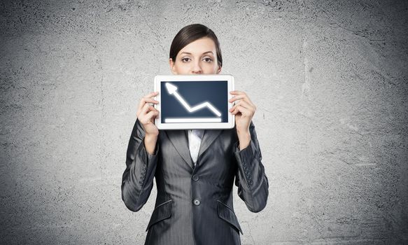 Businesswoman holding tablet computer with growing chart on screen. Beautiful woman in business suit show tablet PC. Corporate businessperson on grey wall background. Digital technology layout.