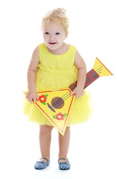 Little girl in a yellow dress holding a Russian balalaika. Isolated on white background .
