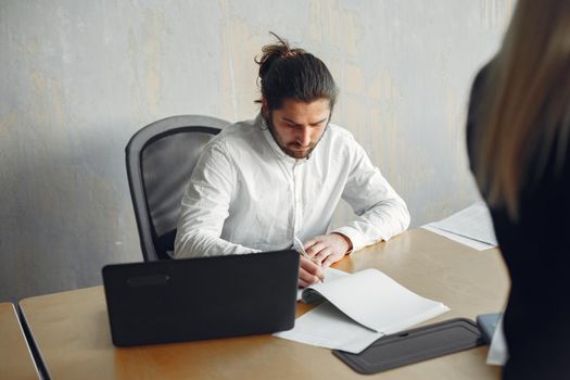 Handsome man in a white shirt. Partners together. Guy with a laptop.