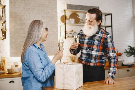 Age and people concept . Senior couple at home. People with champagne.