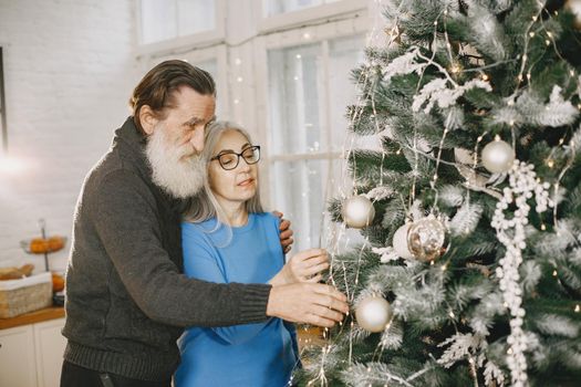 Age and people concept . Senior couple at home. Woman in a blue knited sweater.