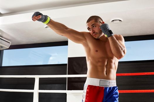 Boxer in grey gloves warming up in the gym. naked torso.