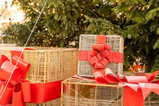 Stylish christmas gift boxes with ribbons and bows in window store in evening. Christmas festive street decor, holiday winter shopping and sales. Merry Christmas