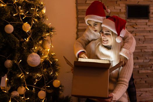 Daughter with her mother near the Christmas tree.