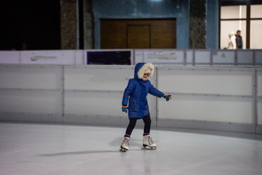 Little girl learning to skate at the rink.