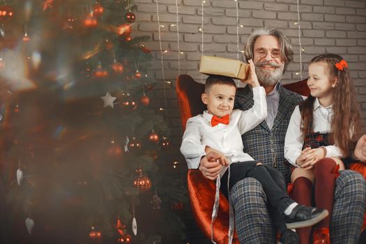 Family, holidays, generation, christmas and people concept . Children in a room decorated for Christmas on the background of a Christmas tree.