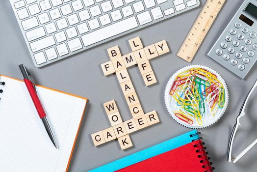 Business motivation concept with words from cubes. Still life of office workplace with crossword. Flat lay grey surface with computer keyboard and stationery. Strategy planning and business analytics.