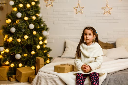 Happy little smiling girl with christmas gift box