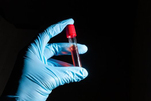 Hand in medical glove hold coronavirus Covid-19 vaccine bottle, closeup detail