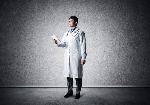 Doctor with a computer tablet. stands alone in the room