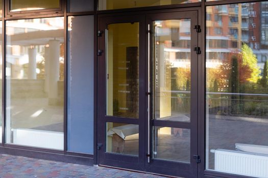 The front door of a office block, reflecting buildings in the glass.