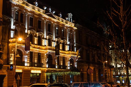Lviv, Ukraine old town rynok market square alley in Lvov with winter Christmas illumination at night with snow.