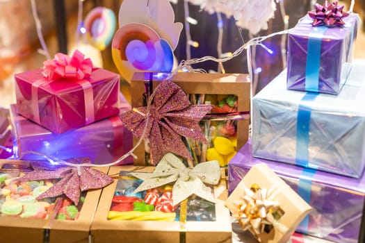 Outdoor Christmas holiday presents decorations gift boxes tied to tree on town street winter idea concept fun.