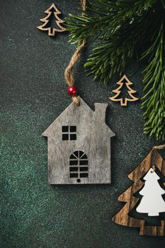 Overhead shoot of toy wooden house, christmas tree and decoration. Winter holidays background with copy space, flat lay, top view.