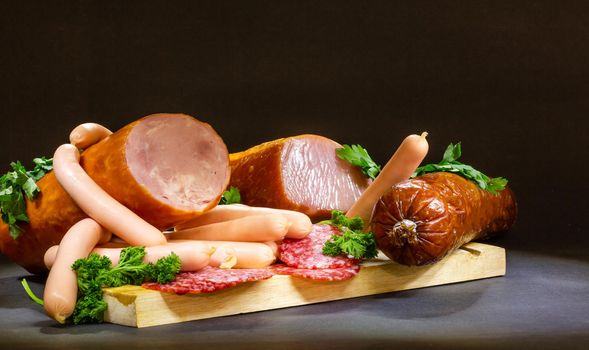 composition of cold cuts on wooden board with different type of cheese