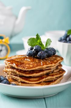 Delicious pancakes with chocolate drops, honey and blueberries. Healthy breakfast concept with copy space.