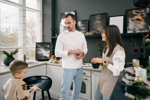 Happy young family spending time together in kitchen at home at Christmas holidays