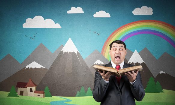 Surprised businessman holding open old book. Startled adult man in business suit and tie standing on background of nature landscape with mountains and rainbow illustration. Education and knowledges.
