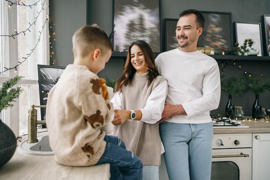 A portrait of happy family in the kitchen decorated for Christmas holidays