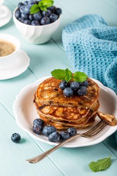 Delicious pancakes with chocolate drops, honey and blueberries. Healthy breakfast concept.