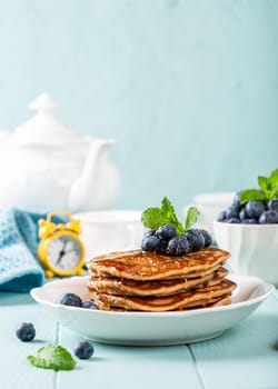 Delicious pancakes with chocolate drops, honey and blueberries. Healthy breakfast concept with copy space.