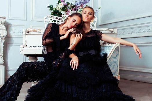 two young pretty lady in black lace fashion style dress posing in rich interior of royal hotel room, luxury lifestyle people concept closeup