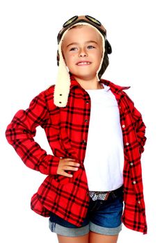 Little girl in helmet pilot with wooden plane in hand. The concept of family happiness, the embodiment of a dream, a love of travel. Isolated on white background.