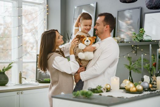 A portrait of happy family in the kitchen decorated for Christmas holidays