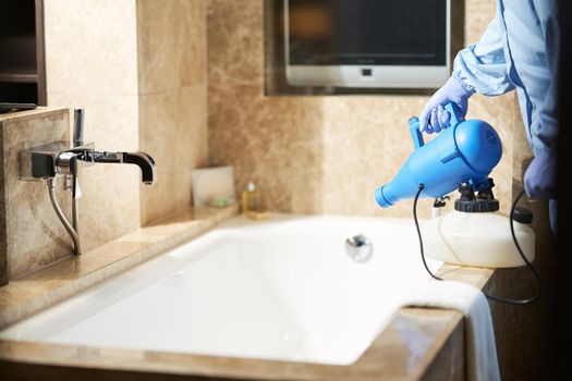 Cropped photo of man using disinfectant for prevent the risk of coronavirus outbreaks in bathroom. Coronavirus and quarantine concept
