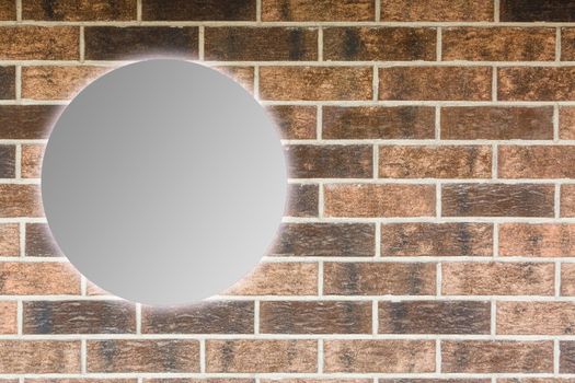 Round mirror near brick wall