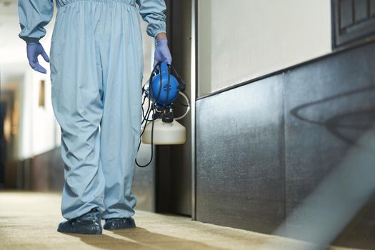 Cropped photo of medical staff wearing protective clothing and disinfecting the public place. Coronavirus and quarantine concept