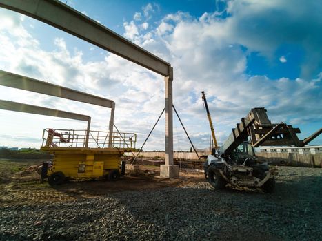 excavator on new construction site, in the background the blue sky and sun