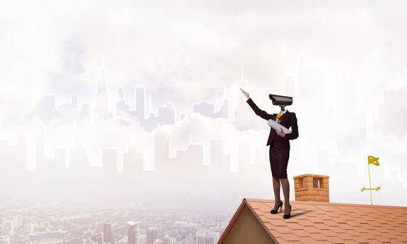 Faceless businesswoman with camera zoom instead of head standing on house roof