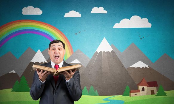 Surprised businessman holding open old book. Startled adult man in business suit and tie standing on background of nature landscape with mountains and rainbow illustration. Education and knowledges.