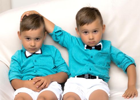 Two little brothers of Gemini together are sad. Isolated on white background