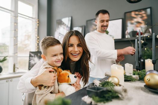 A portrait of happy family in the kitchen decorated for Christmas holidays