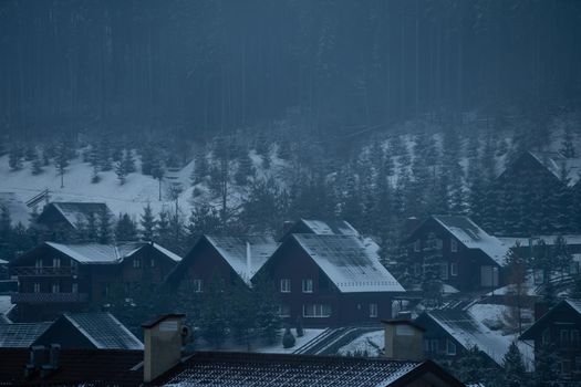Beautiful winter landscape in the mountain village. Foggy morning