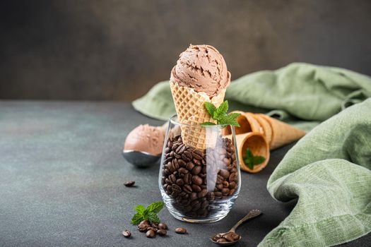 Delicious coffee or chocolate ice cream in waffle cone for dessert. Summer healthy food concept, lactose free. Copy space.