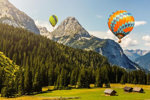 Sunset over forest mountain with hot air balloon.